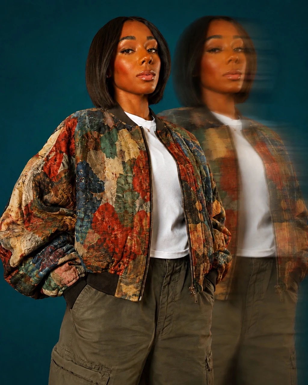 Nyla standing against a deep teal backdrop with a motion-blurred double